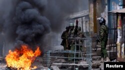 Des policiers se mettent à couvert durant des affrontements contre les forces de l’ordre à Mathare, Nairobi, Kenya, 12 août 2017.