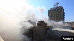 Smoke rises from the site of a bomb attack near Khullani Square in Baghdad, Feb. 5, 2014. 