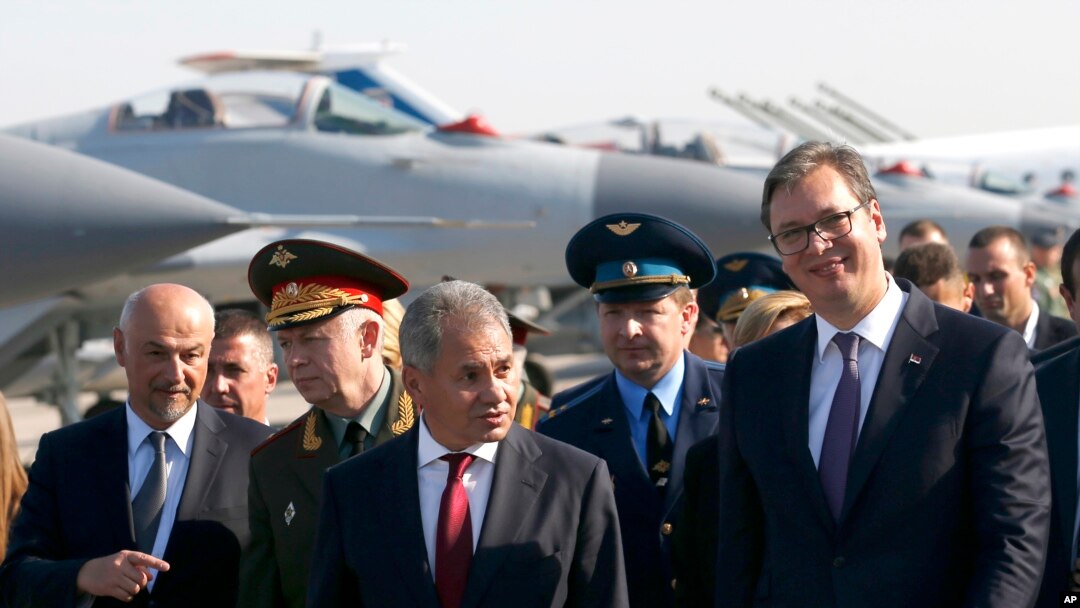 Predsednik Srbije Aleksandar Vučić, desno, i ruski ministar odbrane Sergej Šojgu, u centru, hodaju poed lovaca MiG-29 tokom ceremonije na Batajnici, vojnom aerodromu u blizini Beograda, 20. oktobra 2017.