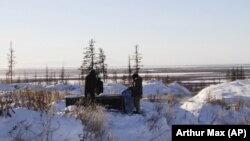 Ilmuwan Rusia Sergey Zimov dan putranya Nikita Zimov mengekstrak sampel udara dari tanah beku di dekat kota Chersky di Siberia 6.600 km (4.000 mil) timur Moskow, Rusia. (Foto: AP/Arthur Max)
