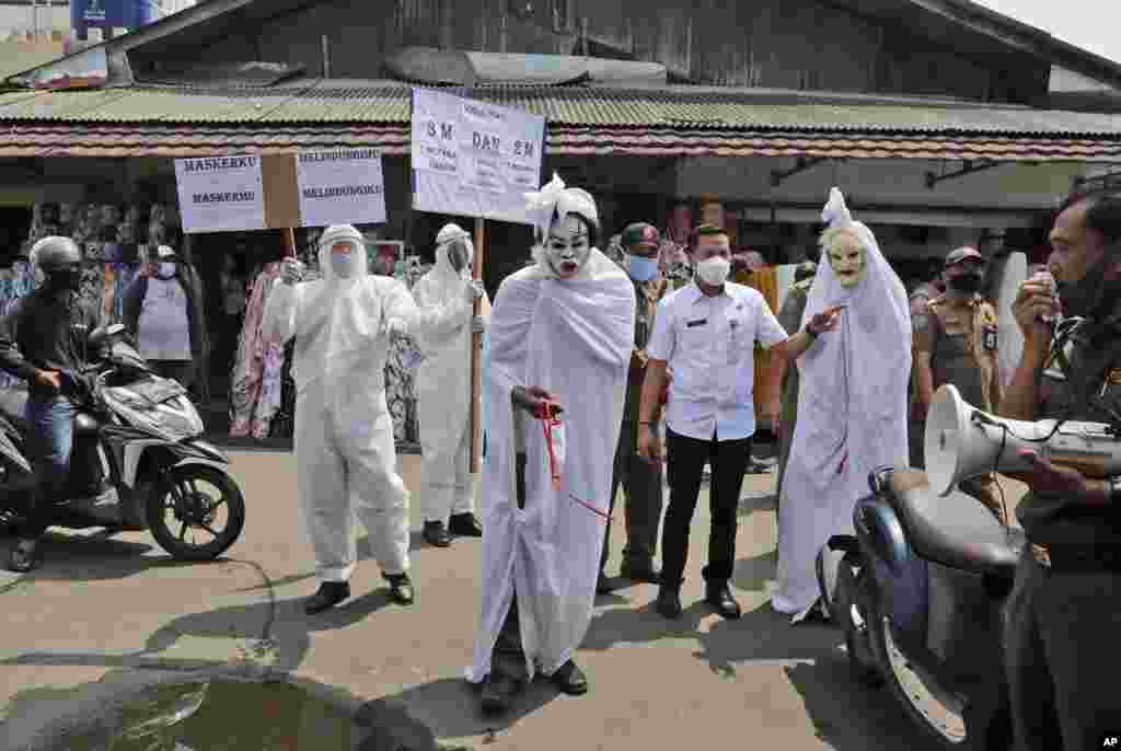 Government officials dressed as ghosts, traditionally known as a &#39;pocong&#39;, to represent the victims of COVID-19, take part in a coronavirus prevention campaign at a market in Tangerang, Indonesia.