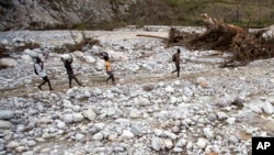 Des résidents marchent près de la rivière Bois Droit, à Port-a-Piment, le 18 octobre 2016 à Haïti. 