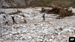 Des Haïtiens marchent près de la rivière de Bois Droit, à Port-a-Piment, le 18 octobre 2016.