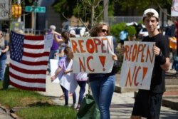FILE - Protesters from a grassroots organization called “REOPEN NC” demonstrate against the North Carolina coronavirus lockdown at a parking lot adjacent to the North Carolina State Legislature in Raleigh, North Carolina, April 14, 2020.