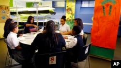 First lady Michelle Obama, center left, pours a smoothie while visiting students at Philip's Academy Charter School in Newark, N.J., as part of her American Garden Tour, April 7, 2016.