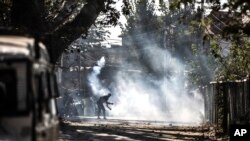 Pengunjuk rasa Kashmir melemparkan bom asap ke arah pasukan pemerintah dalam bentrokan menyusul pembunuhan dua tersangka pemberontak dalam baku tembak dengan pasukan pemerintah di Srinagar, Kashmir yang dikendalikan India, Senin, 12 Oktober 2020.