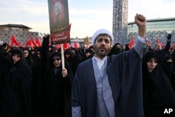 A Muslim cleric chants slogans alongside women in a rally to protest the execution by Saudi Arabia last week of Sheikh Nimr al-Nimr, a prominent opposition Saudi Shiite cleric, in Tehran, Iran, Jan. 4, 2016.