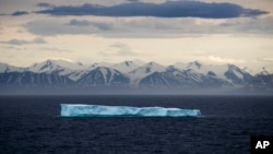 FILE - An iceberg floats past Bylot Island in the Canadian Arctic Archipelago, July 24, 2017.