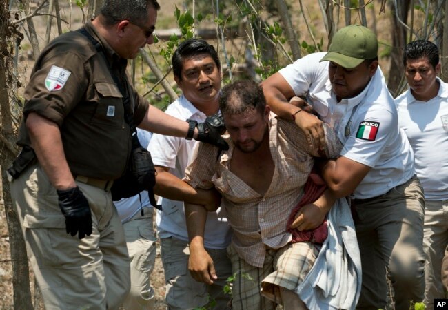 A Central American migrant is detained by Mexican immigration agents on the highway to Pijijiapan, Mexico, April 22, 2019.