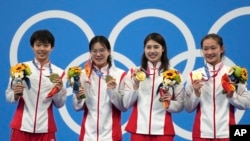 资料照片：中国女子4x200米自由泳接力队员在日本东京举行的2020年夏季奥运会上举着金牌合影。（2021年7月29日）