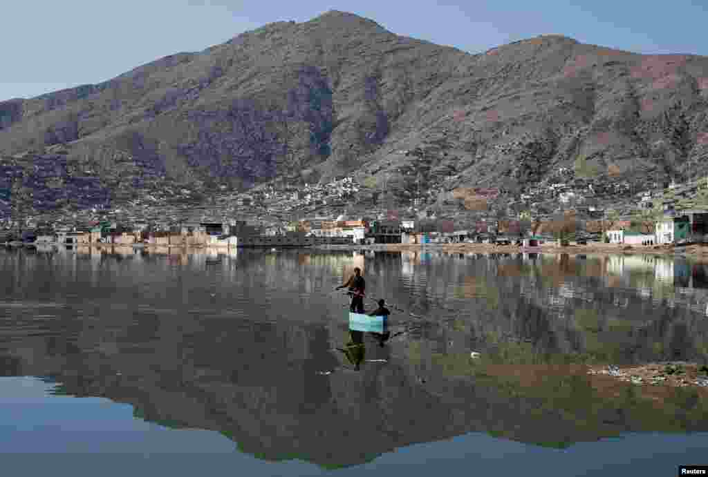 Afghan men row a raft on a lake in Kabul, Afghanistan.