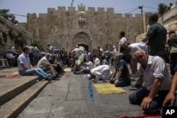 Palestinians pray outside the Lion's Gate in Jerusalem's Old City, July 21, 2017. Thousands of Muslims prayed on mats spread on cobble stone to protest the installation of metal detectors at the holy site.