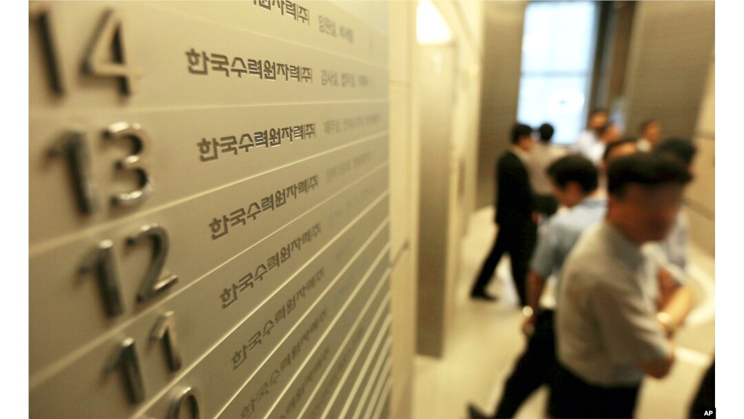 FILE - Employees of Korea Hydro & Nuclear Power Co. walk inside the company's Seoul office, which in 2014 faced a cyberattack in which hackers stole and released information.