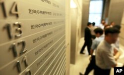 FILE - Employees of Korea Hydro & Nuclear Power Co. walk inside the company's Seoul office, which in 2014 faced a cyberattack in which hackers stole and released information.
