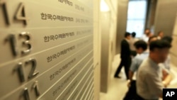 FILE - Employees of Korea Hydro & Nuclear Power Co. walk inside the company's Seoul office after prosecutors seized documents and computer hard drives in South Korea.