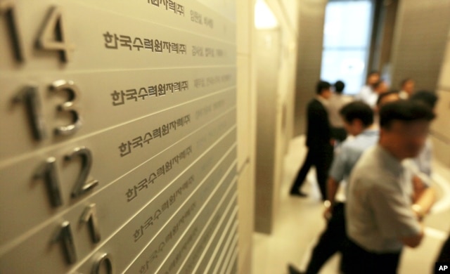 FILE - Employees of Korea Hydro & Nuclear Power Co. walk inside the company's Seoul office, which in 2014 faced a cyberattack in which hackers stole and released information.