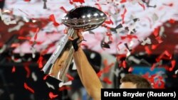 Tampa Bay Buccaneers' Tom Brady celebrates with the Vince Lombardi trophy after winning the Super Bowl.