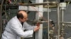 یکی از بازرسان آژانس بین المللی انرژی اتمی در حال از کار انداختن سانتریفیوژهای تاسیاست نطنز - ۲۰ ژانویه ۲۰۱۴ 