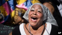 A reveler dressed as nun sings and dances during the "Carmelitas" carnival parade in Rio de Janeiro, Brazil, Feb. 13, 2015. 