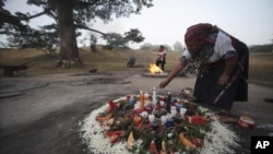 An indigenous woman prepares a sacred fire during the Oxlajuj Batz ceremony to celebrate the end of the Maya calendar in the ceremonial center of Kaminal Juyu in Guatemala City, December 12, 2012.