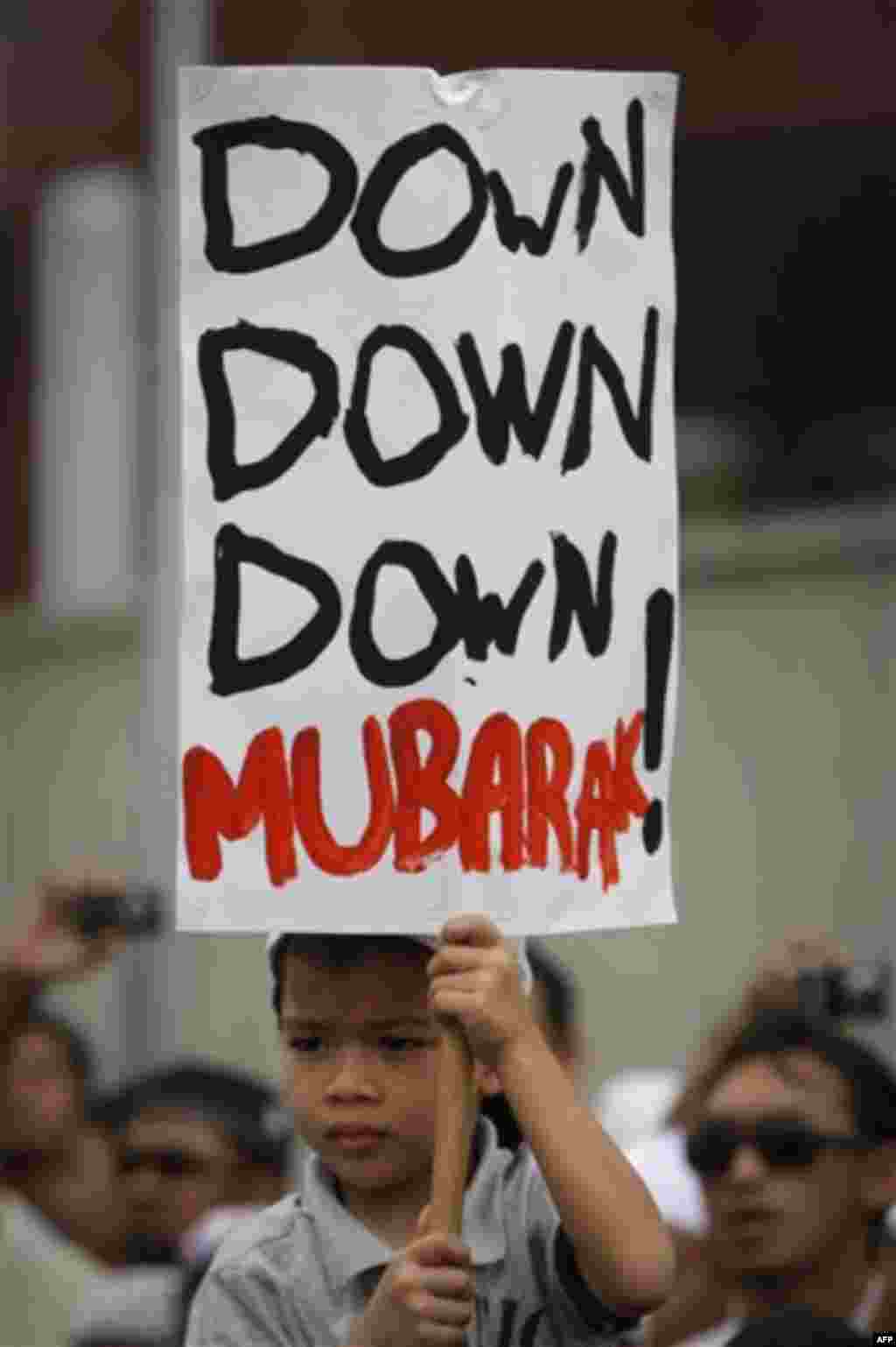 A child holds up a sign protesting against Egyptian President Hosni Mubarak during a rally in front of U.S. Embassy in Kuala Lumpur, Malaysia, Friday, Feb. 4, 2011. More than 1,000 people protested outside the embassy, calling for Mubarak to step down. (A
