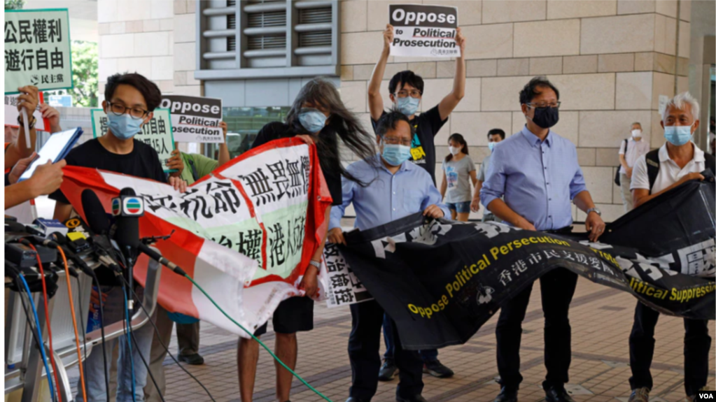  梁国雄(左二)等民主派积极分子香港区域法院外手持横幅抗议政治迫害。（2020年7月30日）