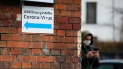 Un hombre con máscara protectora camina por uno de los centros de información sobre el coronavirus en Berlín, Alemania.