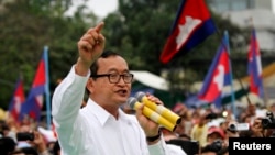 FILE - Sam Rainsy (C), leader of the opposition Cambodia National Rescue Party is seen speaking at a protest in central Phnom Penh, December 17, 2013.