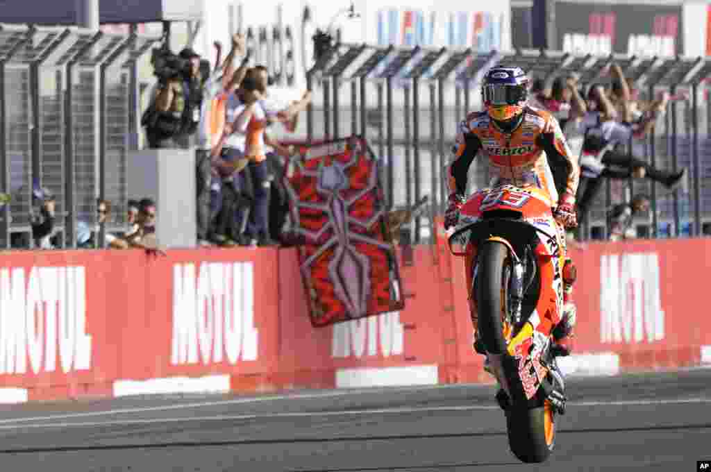Spain&#39;s rider Marc Marquez celebrates after crossing the finish line to win the MotoGP Japanese Motorcycle Grand Prix at the Twin Ring Motegi circuit in Motegi, north of Tokyo.