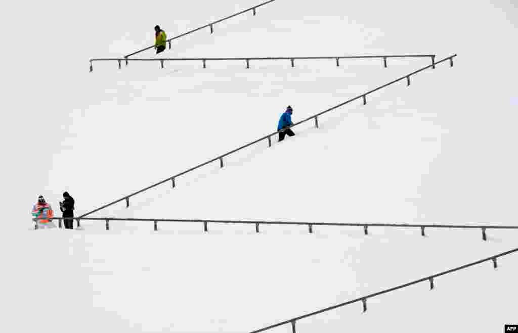 People walk at a snowy stairs of the Garmisch-Partenkirchen hill ahead the qualification jump of the second session of the Four-Hills Ski jumping tournament (Vierschanzentournee) in Garmisch-Partenkirchen, southern Germany.