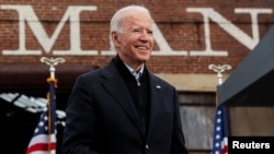 Presiden terpilih AS Joe Biden memegang maskernya saat dia berkampanye atas nama kandidat Senat Demokrat AS dari Georgia Jon Ossoff dan Raphael Warnock, menjelang pemilihan putaran kedua 5 Januari. (Foto: Reuters)