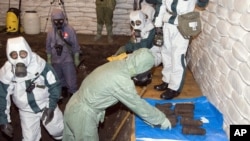 Para ahli senjata kimia China dan Jepang mengenakan pakaian pelindung untuk mengumpulkan senjata kimia peninggalan masa perang di Ning'an, timur laut provinsi Heilongjiang China, 5 Juli 2006 (Foto: dok). 