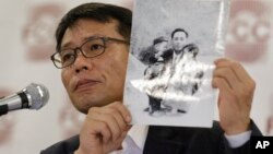 북한의 대한항공 납치 피해자 황원 씨의 아들인 황인철 씨가 지난 5월 서울 외신클럽 기자회견에서 어린 시절 아버지와 찍은 사진을 들어 보이고 있다. 황인철 씨는 아버지를 포함한 납북자들에 대한 국제사회의 관심을 촉구했다.