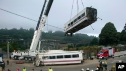 Tim SAR menggunakan mesin derek untuk memindahkan gerbong-gerbong kereta dari lokasi kecelakaan hari Kamis (25/7).