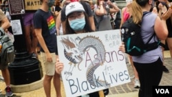一名手持中文牌子的抗议者参加在华盛顿2020年6月6日举行的反警暴游行。（美国之音记者文灏拍摄）