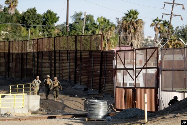 Marines patrol during work to fortify the border structure that separates Tijuana, Mexico, behind, and San Diego, near the San Ysidro Port of Entry, Nov. 9, 2018, in San Diego.