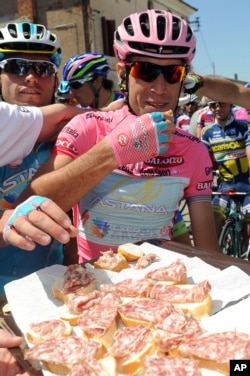 An Italian cyclist eats a sandwich after the final stage of the Giro d'Italia in 2013.