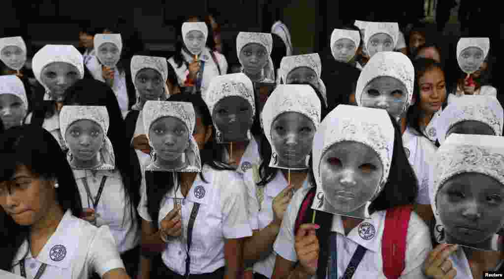 Students from an all-girls Catholic school, St. Scholastica&#39;s College, wear masks depicting kidnapped African school girls in Manila, the Philippines. More than 1,000 girls took part in the protest aimed at voicing outrage over the kidnapping of more than 200 girls from a northeast Nigerian school in April by Boko Haram militants. 