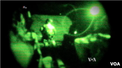FILE - Screengrab of a video shot through night-vision lens shows U.S. servicemen conducting a mission in Iraq.
