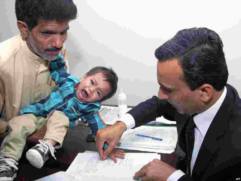 A Pakistani lawyer taking a thumb impression from nine-month-old toddler Mohammad Musa on a bail bond in Lahore. Baby Musa has been accused of attempted murder in a case observers say highlights endemic flaws in the country&#39;s legal system. The baby along with his father and other family members was booked for throwing rocks at gas company officials in the working-class Ahata Thanedaran neighbourhood on Feb. 1, the family&#39;s lawyer Chaudhry Irfan Sadiq told AFP.