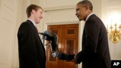 El presidente Obama conversa con un estudiante durante la Feria de Ciencias de la Casa Blanca de 2013.