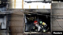 Petugas pemadam kebakaran memeriksa sebuah panti wreda yang membantu manula dengan masalah kesejahteraan, yang terbakar di Sapporo, 1 Februari 2018. (Foto:Kyodo via Reuters)