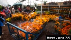 Orang-orang berbelanja bunga marigold di pasar bunga Xochimilco, di pinggiran Mexico City, Rabu, 14 Oktober 2020. (Foto: AP/Marco Ugarte)