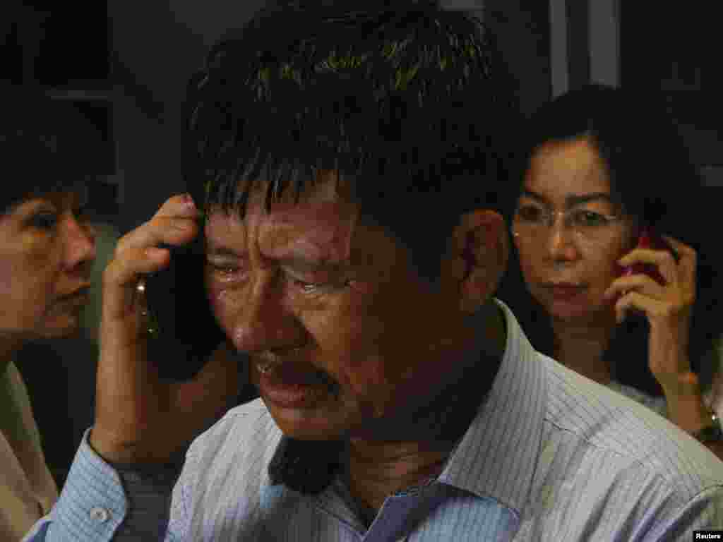 Family members of passengers on board AirAsia flight QZ 8501 talk on their phones while waiting for information at Juanda Airport in Surabaya, East Java, Dec. 28, 2014. (Antara Foto)