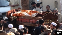 Local residents carry the coffin of a bomb blast victim during a funeral in Mingora, Pakistan, January 11, 2013.