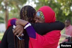 FILE - Members of the #BringBackOurGirls (#BBOG) campaign embrace each other at a sit-out in Abuja, Nigeria, May 18, 2016.