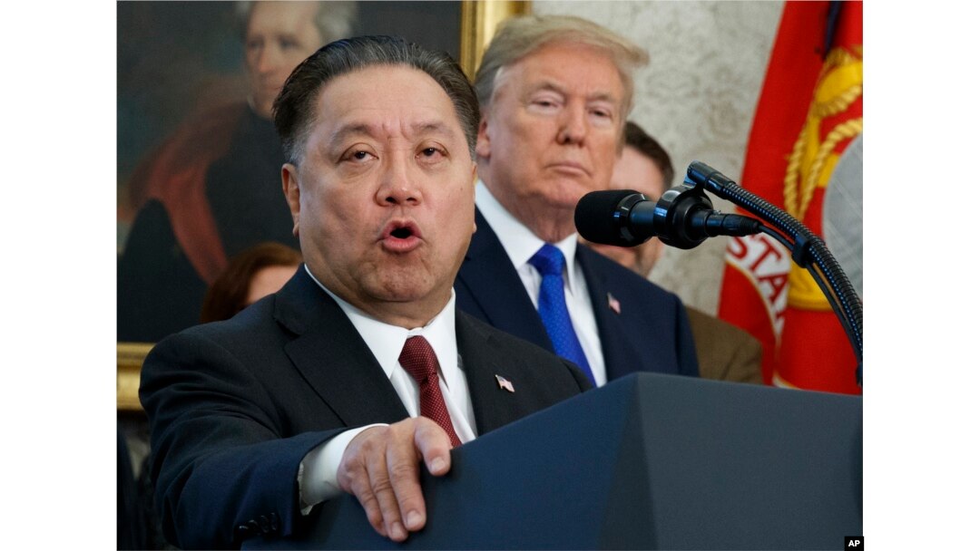 FILE - Broadcom CEO Hock Tan speaks while U.S. President Donald Trump listens during an event at the White House in Washington, Nov. 2, 2017.