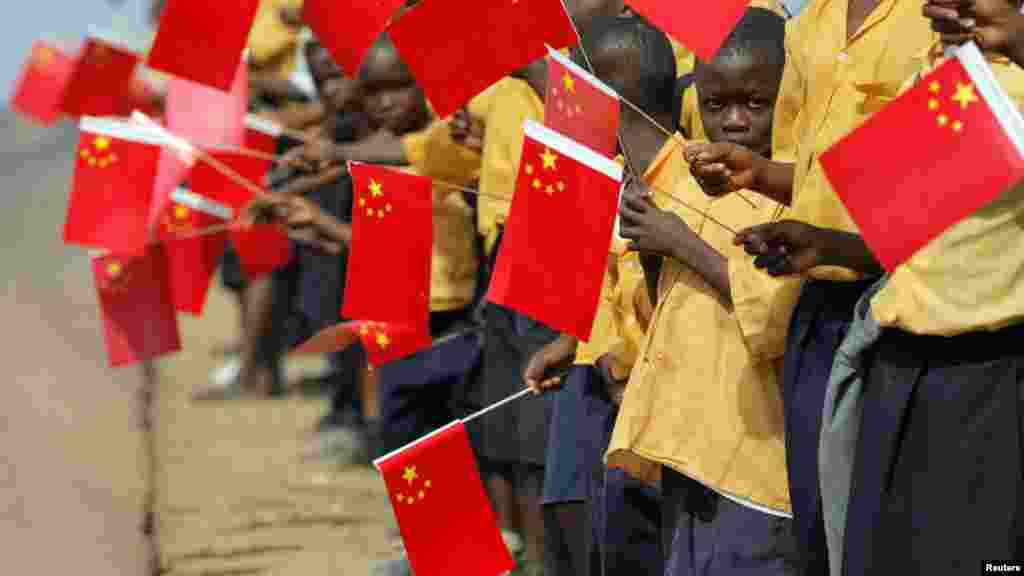 Drapelets chinois en main, les enfants libériens attendent l&#39;arrivée du président chinois Hu Jintao à Monrovia, 1er février 2007.&nbsp;