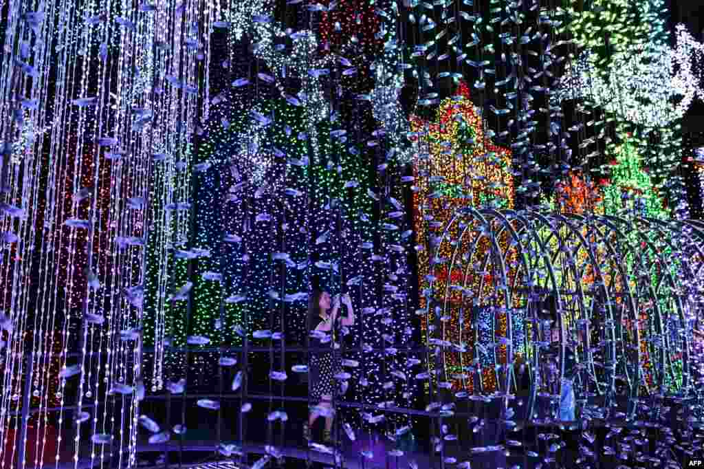 A visitor takes photographs inside the Universal Journey during a media preview of Santa's All-Star Christmas at Universal Studios Singapore in Resorts World Sentosa. Singapore's Universal Studio broke the Guinness World Record for having the largest indoor display of lightbulbs with 824,961 bulbs in a festive light display separated into eight thematic zones.