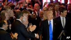 미국 대통령 선거에 출마한 공화당의 도널드 트럼프 경선 후보(오른쪽)가 지난 3일 뉴욕 기자회견장에 도착한 가운데, 지지자들의 박수를 받고 있다. (자료사진) 